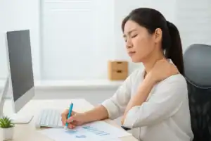 도수치료와 자세 교정이 필요한 상황. 컴퓨터 앞에서 잘못된 자세로 앉아 있는 동양인 여성 직장인,
